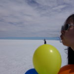 ウユニ塩湖　トリック撮影、風船の上で美女に吹き飛ばされようとしている