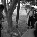モノ村　ユカ芋をすりおろし、筒状の網に入れ木の間に吊るして水分を抜く