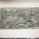 戦いの場面　戦車が敵の歩兵と戦っている。敵兵の死体が戦車の前に横たわっている