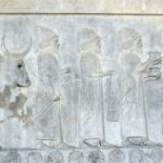 東階段のレリーフ　バビロニア使節、円錐の形の帽子を被っている。貢物は浅い壷、マント、こぶのある牡牛