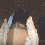 柩を見守る聖女　アルゼンチン、チリ、ペルーの３人の聖女、もう１人は裏側にいる