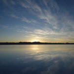 ウユニ塩湖の日の出　太陽が山系に顔を出す寸前、湖面にも映っている