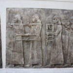 コルサバード　従者が長椅子や丸鉢を運んでいる、宴会の準備のようだ