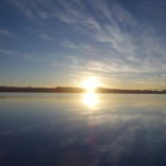 ウユニ塩湖の日の出　太陽は山の上に登った、湖面が眩しい
