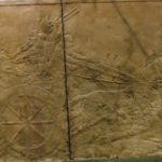 ROOM10（ライオン狩り）　戦車の後から飛び掛ってきたライオンに兵士が槍を突きつけ、王が短剣で喉元を差し仕留めている